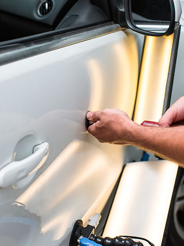 Person working on dent on car
